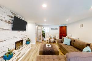 un soggiorno con divano e TV a schermo piatto di Beach house & backyard oasis with private pool - short walk to beach a Baptist Medical Center/Beaches Heliport