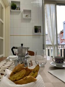 uma mesa com um prato de pão sobre uma mesa em Avolina’s Apartment em Nápoles