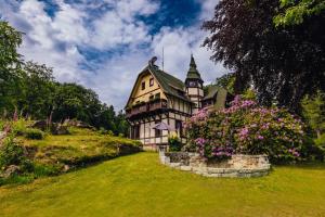 una casa en una colina con flores delante en Weranda, en Szklarska Poręba