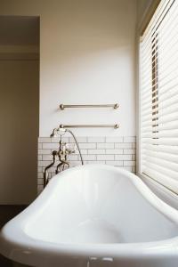 baño con bañera blanca y ventana en Monte Christo Winery Cottages, en Clyde