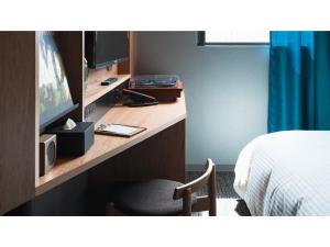een hotelkamer met een bureau met een bed en een stoel bij dogo hakuro - Vacation STAY 80202v in Matsuyama