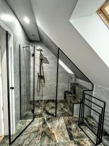 a bathroom with a shower and a staircase at Modern Village in Nowinka