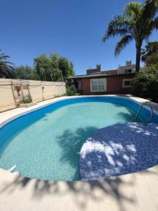 a large swimming pool in a yard with a palm tree at Zorzales in Funes