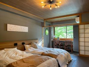 ein Schlafzimmer mit einem Bett und ein Esszimmer mit einem Tisch in der Unterkunft Towadakohan Sakura - Vacation STAY 80357v in Towada