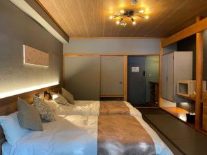a bedroom with a large bed and a tv at Towadakohan Sakura - Vacation STAY 80357v in Towada