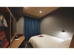 松山市にあるdogo hakuro - Vacation STAY 80196vのベッドとテレビが備わるホテルルームです。