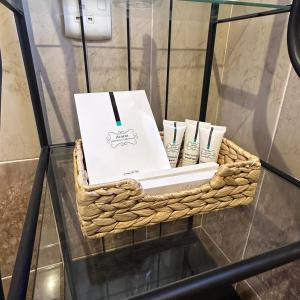 a basket with toothbrushes and a box on a glass table at رغيد للشقق الفندقية حائل in Hail