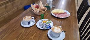 une table avec deux tasses de café et des assiettes de nourriture dans l'établissement Horská bouda Krakonoš, à Černý Důl