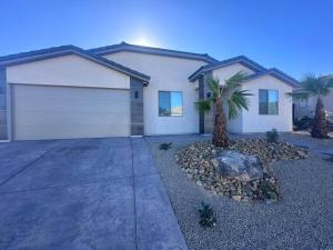 a house with a garage and a palm tree at Desert Gem - Mesquite in Mesquite