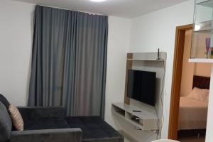a living room with a couch and a flat screen tv at Apart hotel Tagualife in Riacho Fundo