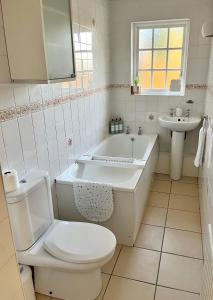 a bathroom with a toilet and a tub and a sink at Clannad Cottage in Arboe