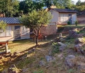 a small house with a tree in the yard at Cabaña 3 in Bialet Massé +3 photos