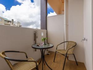 una pequeña mesa y sillas en una habitación con ventana en Yenns Marina Inn Mashiki Condo Hotels - Vacation STAY 85633v en Ginowan