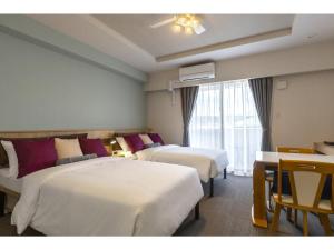 Habitación de hotel con 3 camas y ventana en Yenns Marina Inn Mashiki Condo Hotels - Vacation STAY 85633v en Ginowan