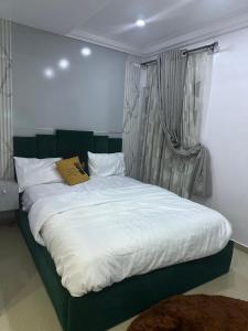 a bedroom with a large bed with white sheets at Daisies in Lekki