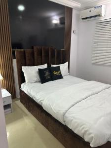 a bed with two pillows on it in a room at Daisies in Lekki