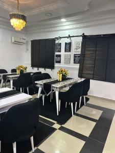 a dining room with tables and chairs and a chandelier at Daisies in Lekki