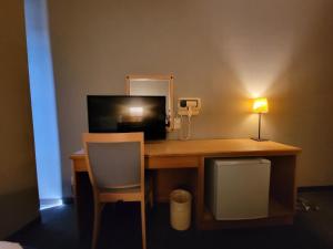 a desk with a television and a lamp and a desk with a chair at HOTEL SEAGULL - Vacation STAY 04622v in Izumi-Sano