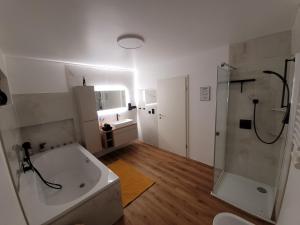 a bathroom with a tub and a shower and a sink at Ferienwohnung Nachtigall 2 in Bad Hersfeld