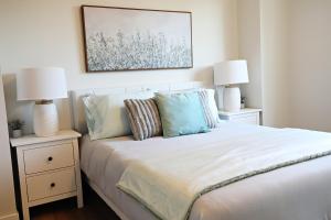 a bedroom with a bed with two night stands with lamps at Central 3 Queen Beds,Double Garage,Disney+ in Edmonton