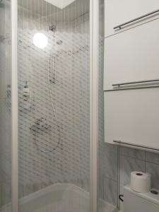 a shower with a glass door in a bathroom at Apartament w centrum in Kętrzyn