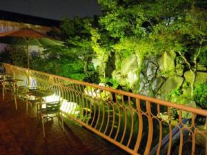 un balcone con tavoli, sedie e ombrellone di HOTEL SEAGULL - Vacation STAY 86778v a Izumisano