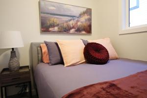 a bedroom with a bed with pillows on it at Central 3 Queen Beds,Double Garage,Disney+ in Edmonton