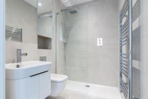a bathroom with a toilet and a sink and a shower at Farringdon Apartments in London