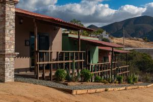 Una pequeña casa con porche y montañas al fondo. en Finca de Lulu y Jose Ruta del Vino, en Valle de Guadalupe 30 fotos más