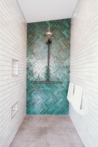 a bathroom with a shower with a mosaic tile wall at Monte Christo Winery Cottages in Clyde