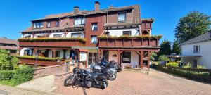 zwei Motorräder, die vor einem großen Haus geparkt sind in der Unterkunft Hotel Ingeburg in Bad Sachsa