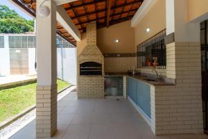 安格拉杜斯雷斯Casa em Angra com Piscina e Descida para Jet Ski的房屋内带砖炉的室外厨房 更多24张照片