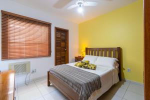 安格拉杜斯雷斯Casa em Angra com Piscina e Descida para Jet Ski的一间卧室设有一张黄色墙壁的大床