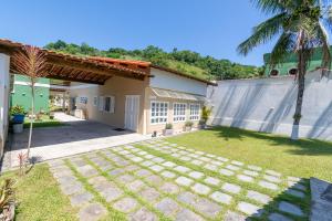 安格拉杜斯雷斯Casa em Angra com Piscina e Descida para Jet Ski的棕榈树房子的后院