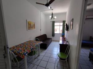 uma sala de estar com uma mesa e um sofá em Seu Apto Praia da Costa Centro 4 Barato Não divide 2Q Completo Ar Cond Fogão Geladeira Excel Localização em Vila Velha mais 14 fotografias