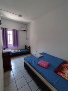 um quarto com uma cama azul e uma janela em Seu Apto Praia da Costa Centro 4 Barato Não divide 2Q Completo Ar Cond Fogão Geladeira Excel Localização em Vila Velha