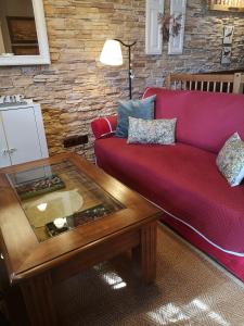 Sala de estar con sofá rojo y mesa de centro en Casita Pirón, en Adrada de Pirón