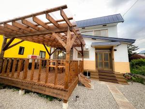 Cosmo st,Inn Noboribetsu - Vacation STAY 87509v في نوبوريبيتسو: سطح به بريغولا خشبي أمام المنزل