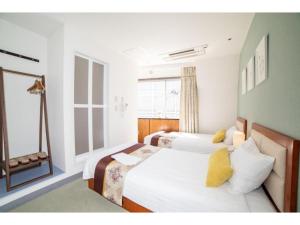東京にあるTabata Oji Hotel - Vacation STAY 89843vのベッド2台と窓が備わるホテルルームです。