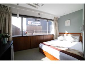 sypialnia z łóżkiem i dużym oknem w obiekcie Tabata Oji Hotel - Vacation STAY 89820v w Tokio