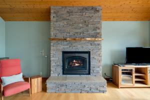 a living room with a stone fireplace with a tv at The View House in Nehalem