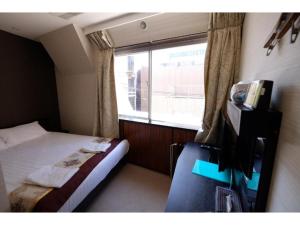 東京にあるTabata Oji Hotel - Vacation STAY 89839vのベッドと窓が備わる小さな客室です。