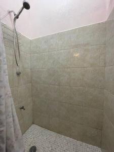 y baño con ducha con cabezal de ducha. en Bonito departamento con dos habitaciones., en Piedras Negras