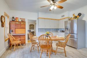 a kitchen with a table and chairs and a refrigerator at Lovely Hixton Home with Porch and Fire Pit! in Black River Falls