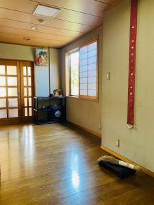 Habitación vacía con suelo y ventanas de madera dura en Ryokankasuga - Vacation STAY 90764v, en Nabari