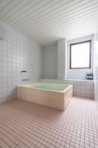 baño blanco con bañera y ventana en Ryokankasuga - Vacation STAY 90764v, en Nabari