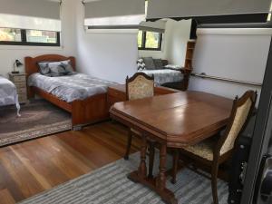 Coffs Harbour Sanctuary في كوفس هاربور: غرفة طعام مع طاولة وسرير وغرفة نوم
