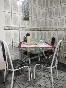 a glass table with two chairs in a room at Apartamento aconchegante em Cacoal4 in Cacoal