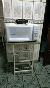 a white microwave on a counter in a kitchen at Apartamento aconchegante em Cacoal4 in Cacoal