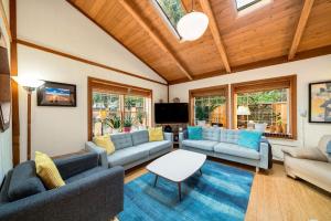 a living room with couches and a flat screen tv at Secret Garden MCA#1504 in Manzanita